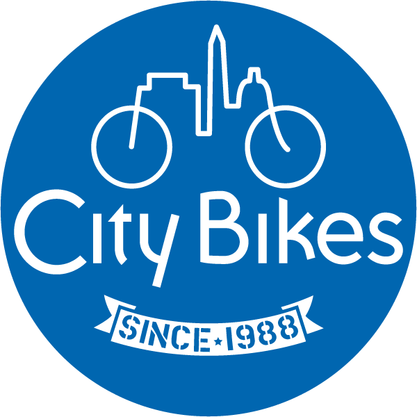 Blue circular logo with a white city skyline forming a bicycle at the top. The text "City Bikes" is centered, and a ribbon below reads "Since 1988" with a star between the words.