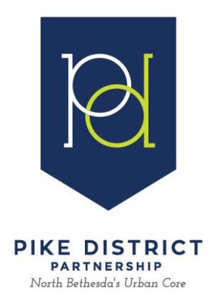 A dark blue shield-shaped logo with interlocking white "p" and green "d" letters. Below, text reads: "Pike District Partnership, North Bethesda's Urban Core.