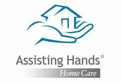 Logo for Assisting Hands Home Care featuring a stylized blue outline of a hand holding a house, with the company name written below in gray and blue text.