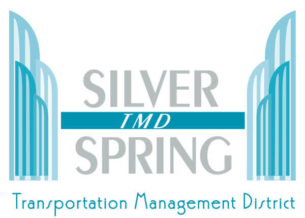 Logo with stylized blue buildings on left and right, "Silver Spring" in large gray letters, "TMD" in white letters on a blue bar, and "Transportation Management District" at the bottom in blue text.