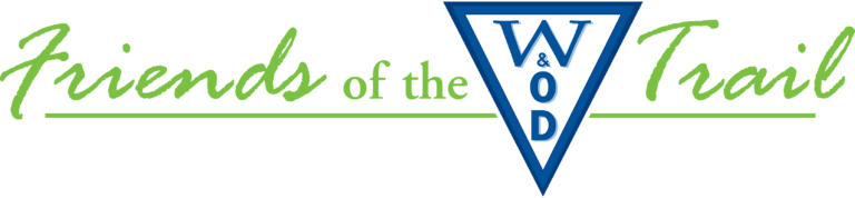 Logo with green italic text reading "Friends of the Trail" and a blue triangle in the center containing stacked white letters "W & O D". A green line runs underneath the text.