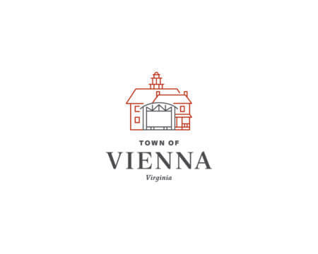 Minimalist line drawing of a barn-like building above the words "Town of Vienna, Virginia" on a white background. The building is outlined in red and has a small cupola on top.